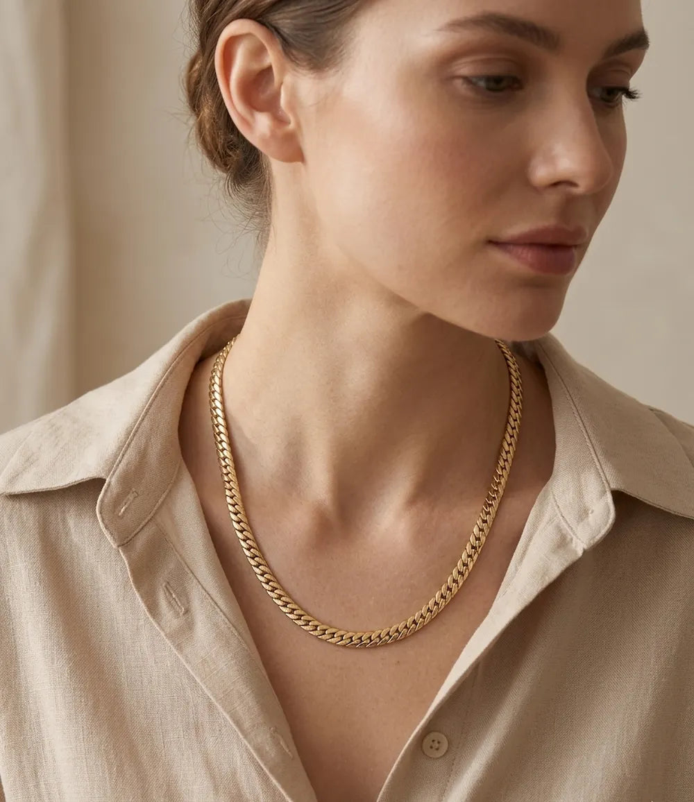 Une femme avec une chemise ouvert au niveau du cou, portant le collier varo de couleur  doré en acier inoxydable 31 par zyora6L