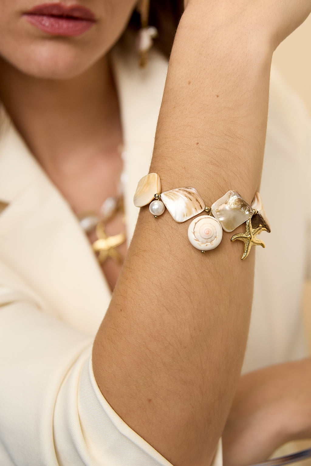 Bracelet orné de coquillages, de breloques marines et de perles dorées