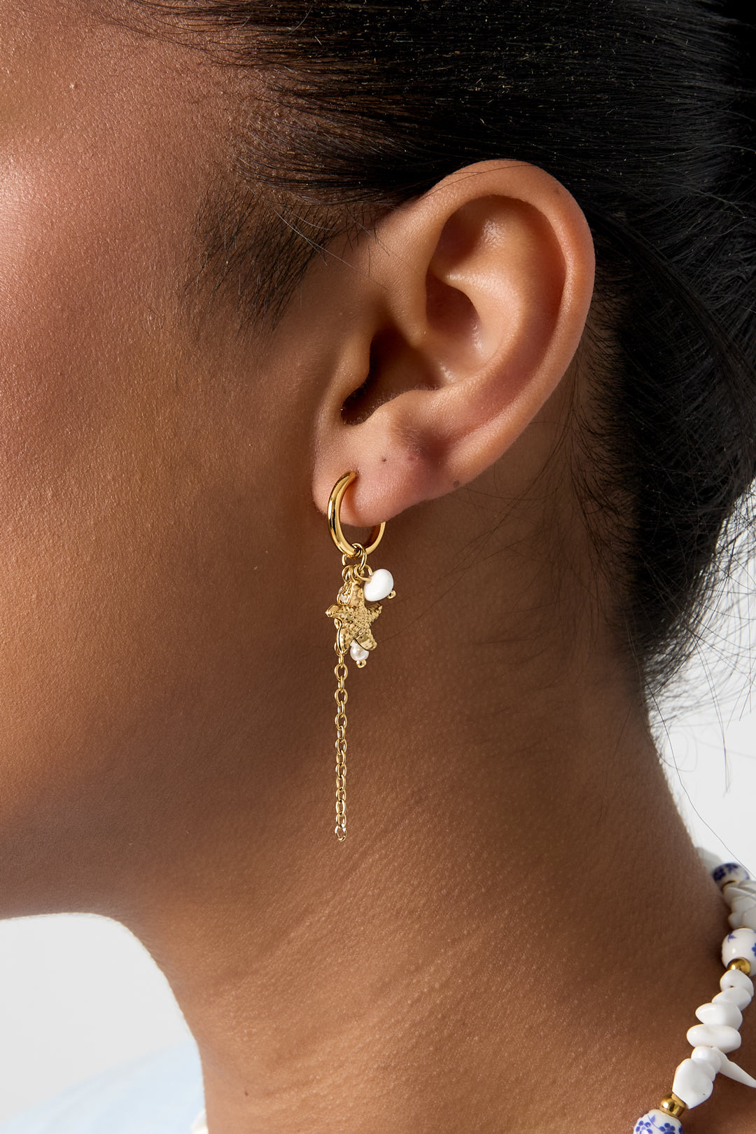 Petites boucles d'oreilles créoles ornées d'étoiles de mer, d'une chaîne, de perles et de perles de rocaille.
