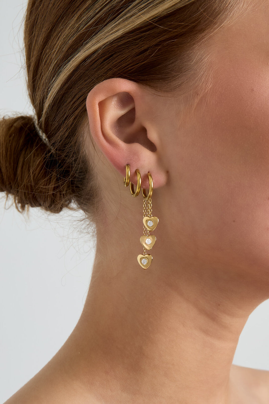 Boucles d'oreilles avec des cœurs pendants à différentes hauteurs
