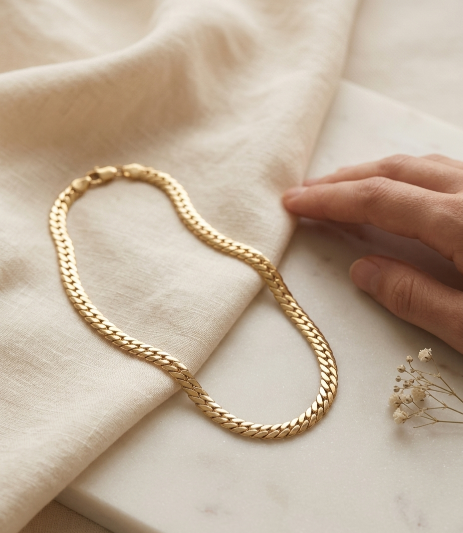 Collier chaine dorée épaisse en acier inoxydable 316L ZYORA photo lifestyle poser sur une table avec une main à coter