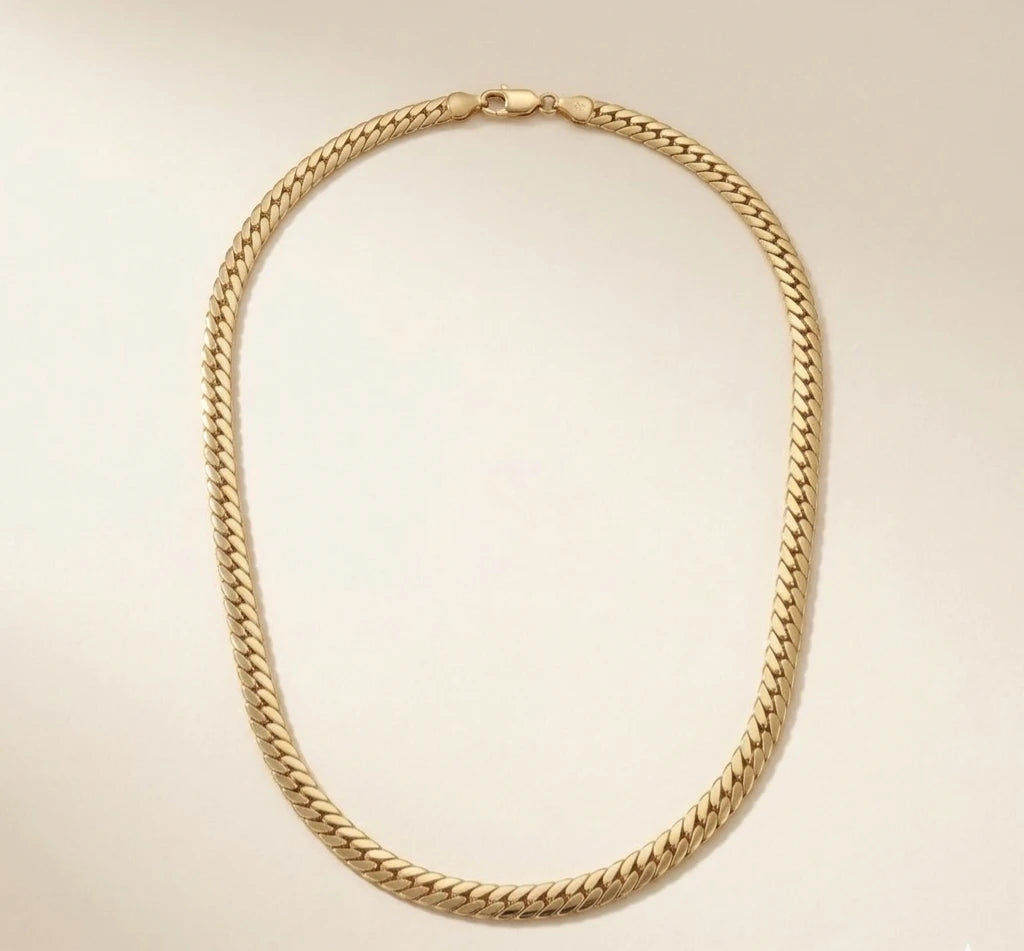 collier varo chaine épaisse poser sur fond beige, en acier inoxydable 316L, couleur or 18 k .hypoallergénique