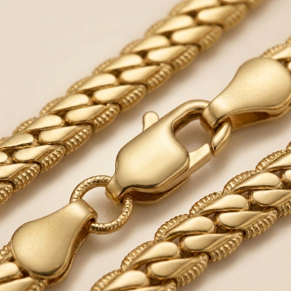 Gros plan sur les maillons fluides et brillants de la maille serpent plate (chevron) de la parure Velis colllier + bracelet en acier inoxydable 316L de couleur doré