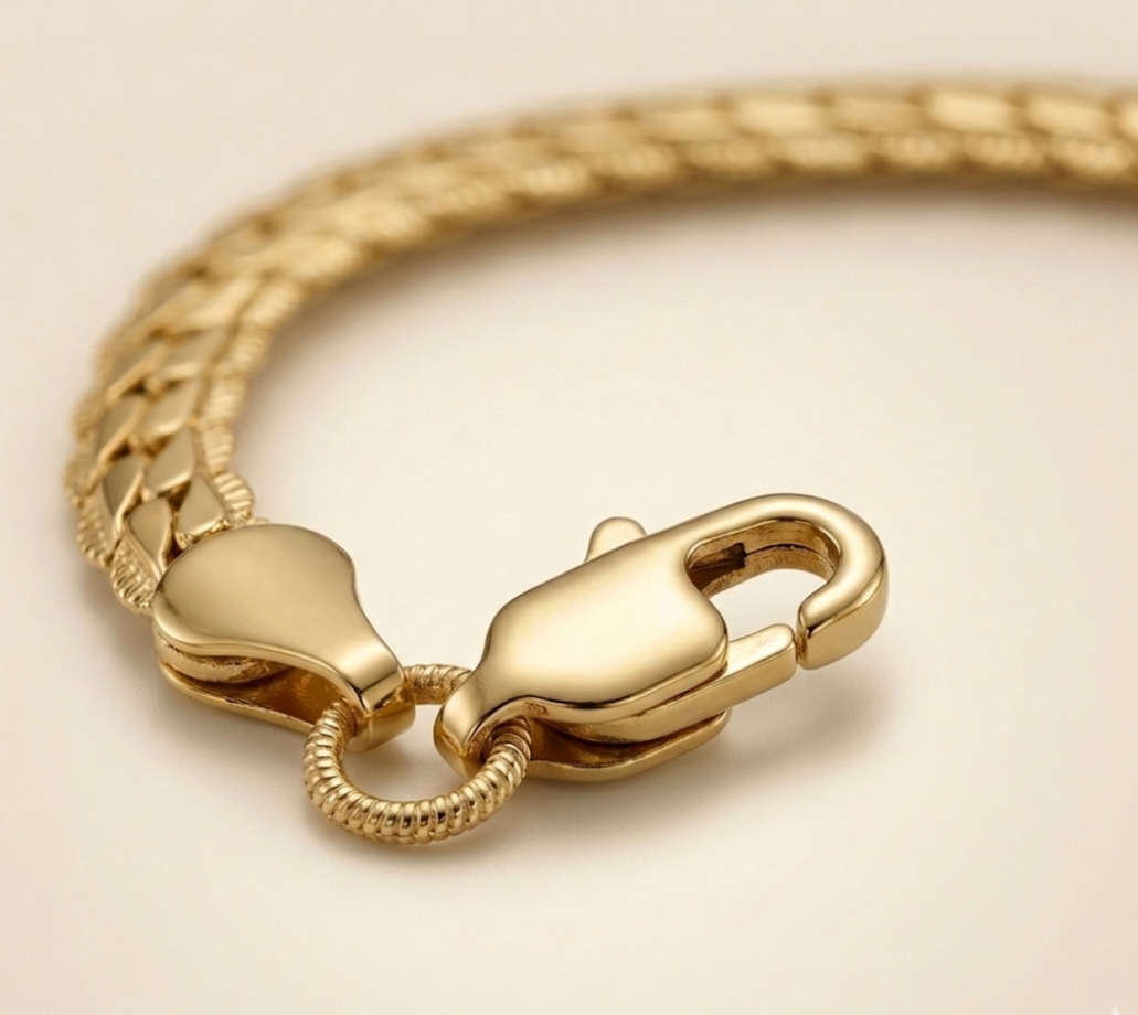 Gros plan du fermoir mousqueton du bracelet femme nova en acier inoxydable de couleur doré