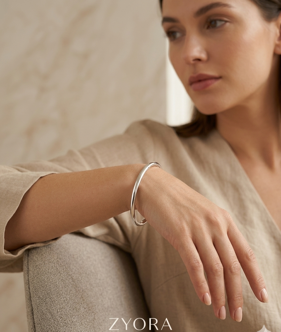 Femme élégante portant le bracelet sora au poignet, manchette minimaliste de couleur  argenté jonc en acier inoxydable 316L  
