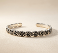 Bracelet jonc ouvert Roséa en acier inoxydable 316l de couleur argenté avec motifs de roses sculptées